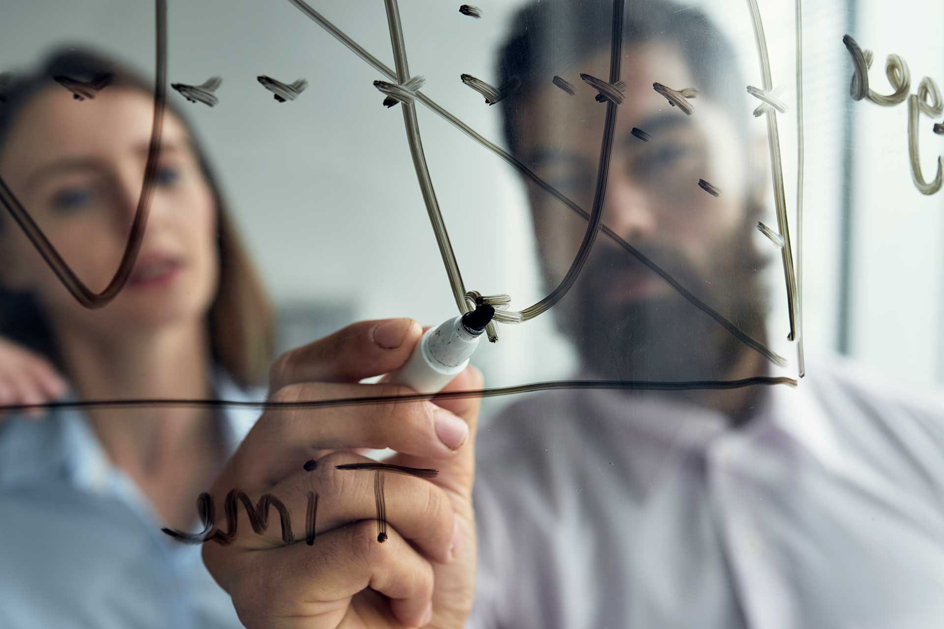 close-up-man-explaining-business-analytics-his-female-colleague-with-graph-whiteboard close-up-man-explaining-business-analytics-his-female-colleague-with-graph-whiteboard